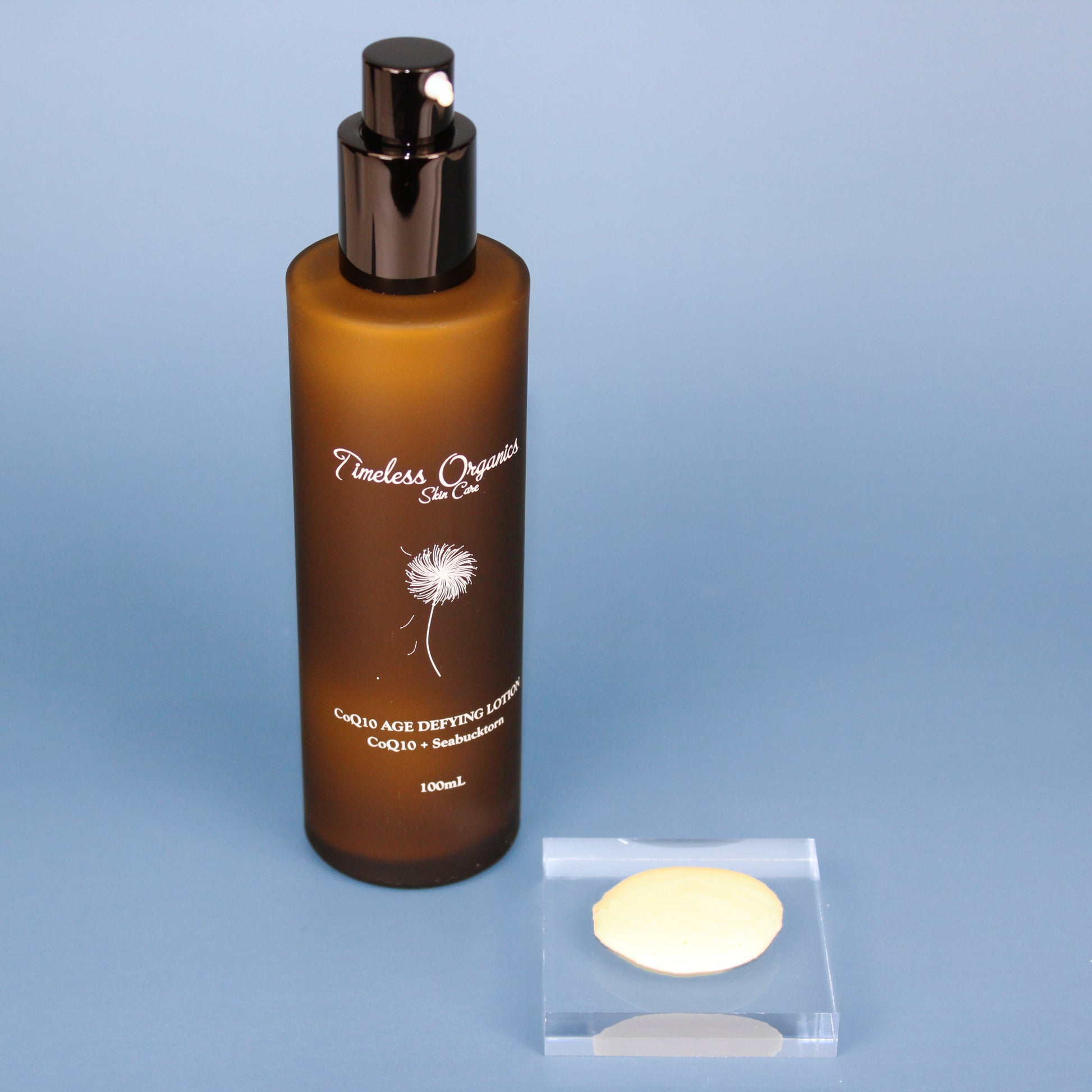 CoQ10 age defying face lotion bottle with black pump and two cream discs