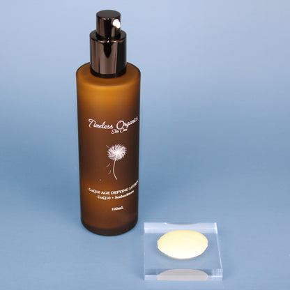 CoQ10 age defying face lotion bottle with black pump and two cream discs