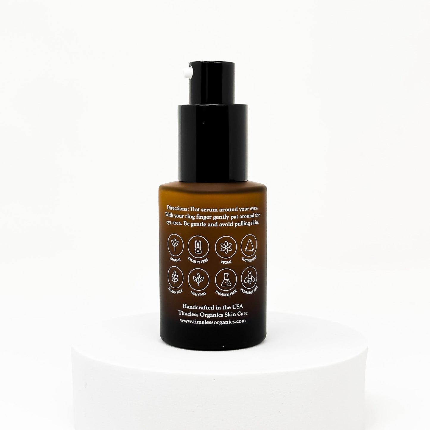Eye serum bottle with black pump, amber container, and illustrated back label
