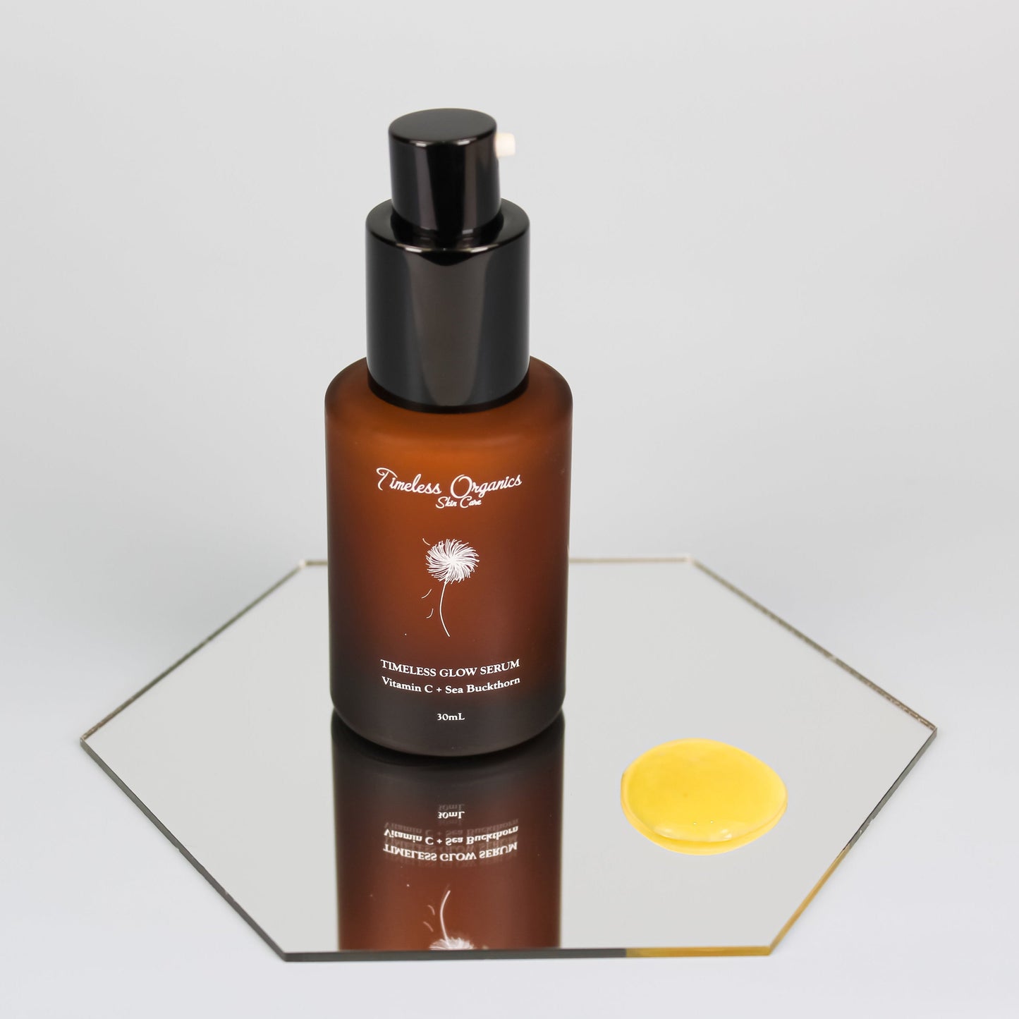 Vitamin C glow serum bottle with black pump and a yellow serum drop.