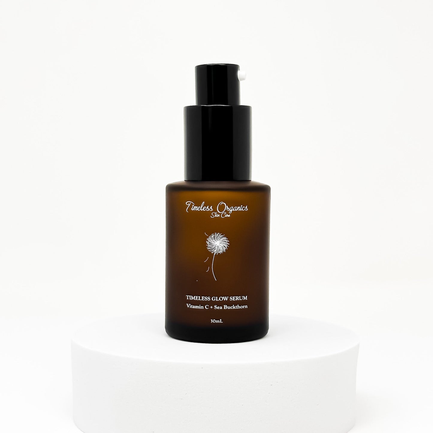 Glow serum bottle with black pump, amber liquid, centered on a pedestal.