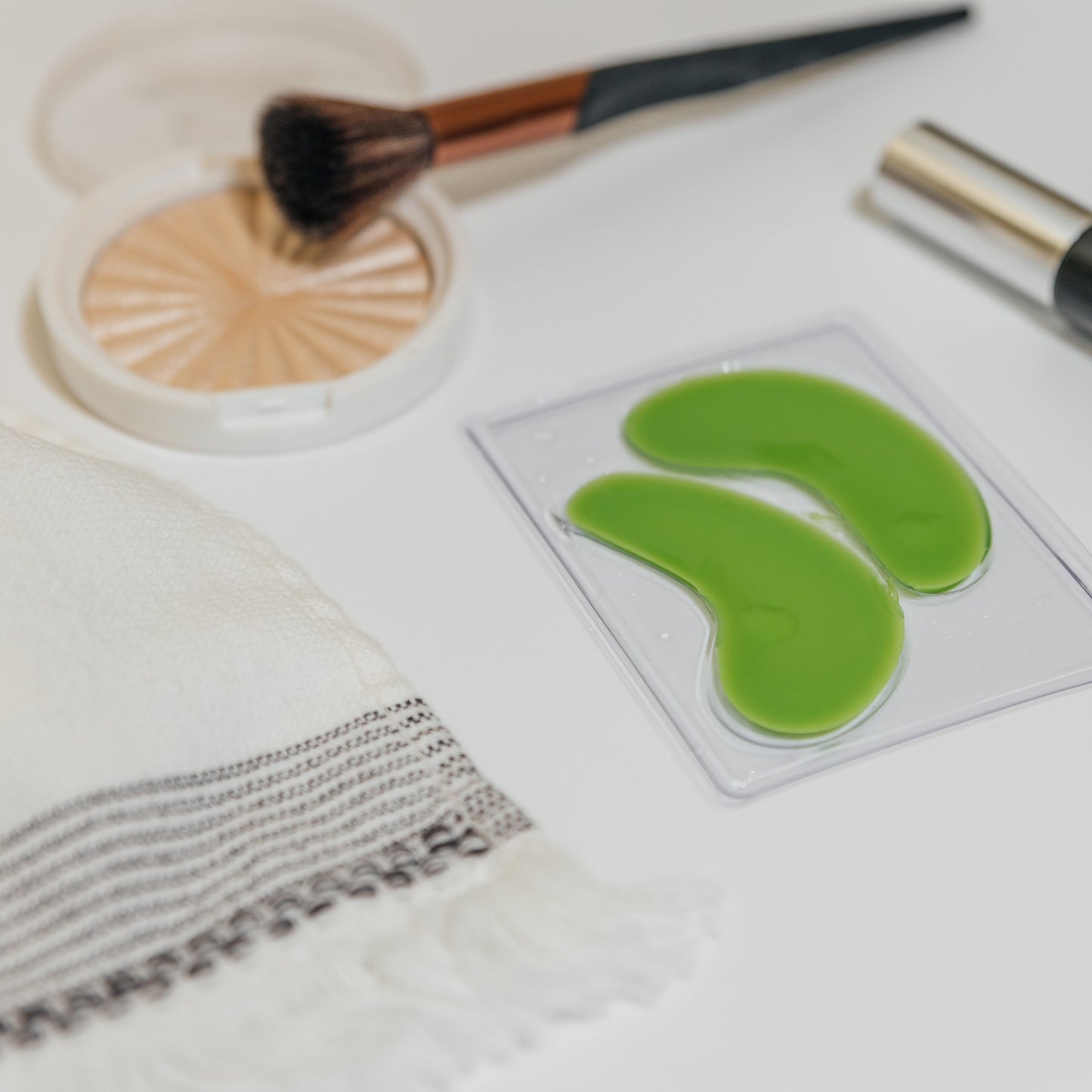 Hydrogel eye masks in clear tray, bright green curved pads for under-eye.