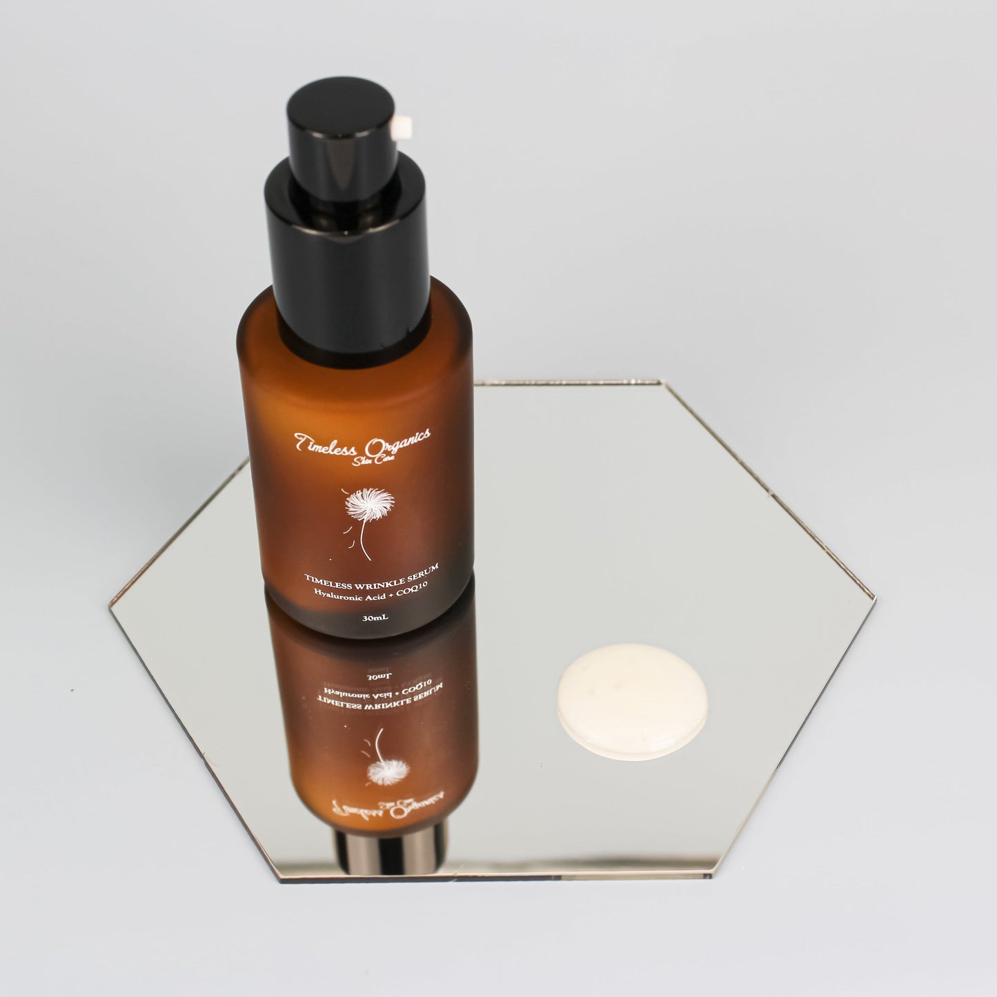 Nighttime wrinkle repair serum bottle with amber liquid and black pump, plus white sample