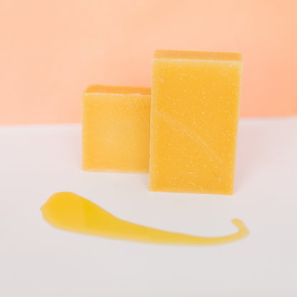 Anti-aging bar soap with yellow-gold block bars and a thin soap smear