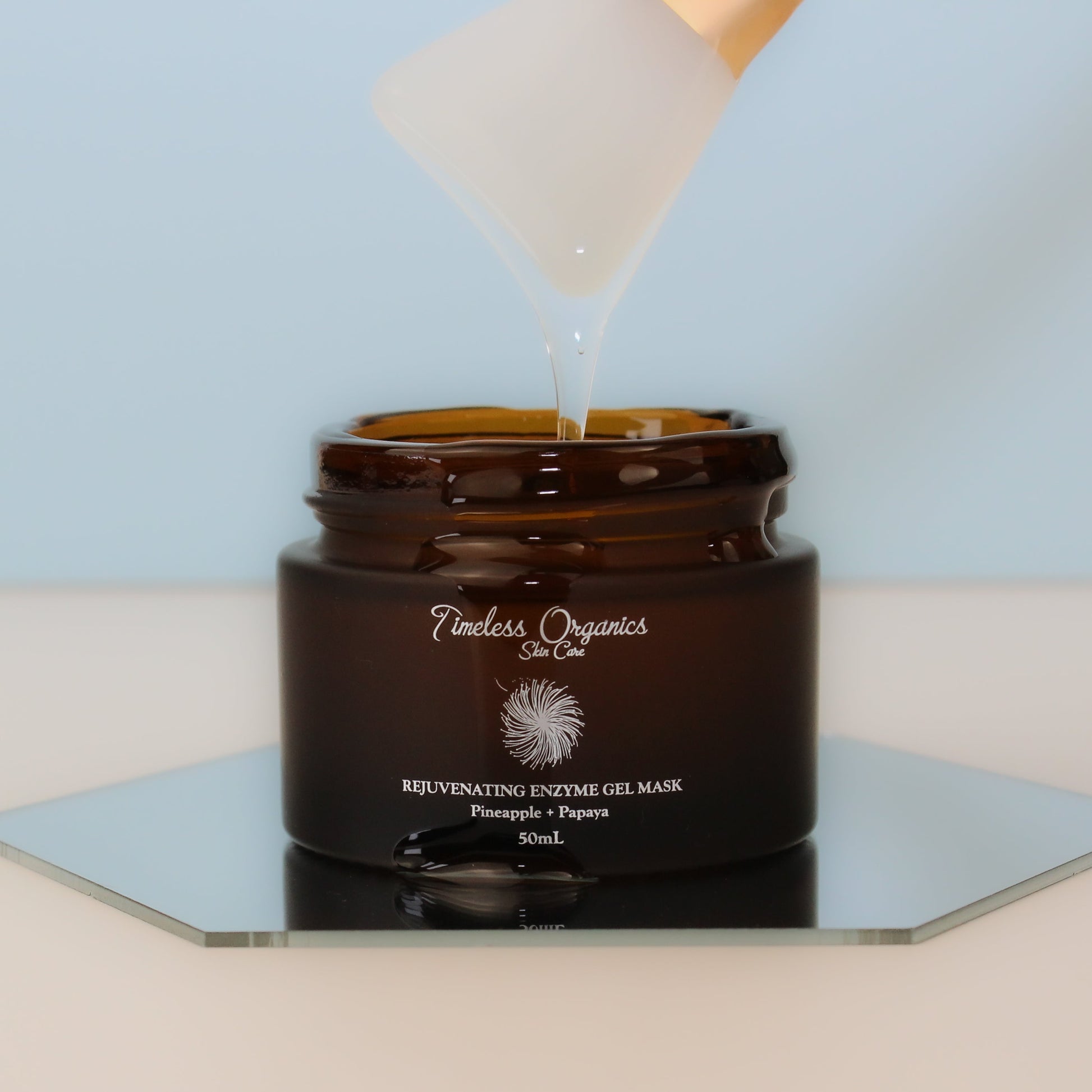 Rejuvenating enzyme gel face mask jar with clear gel stream pouring from cap