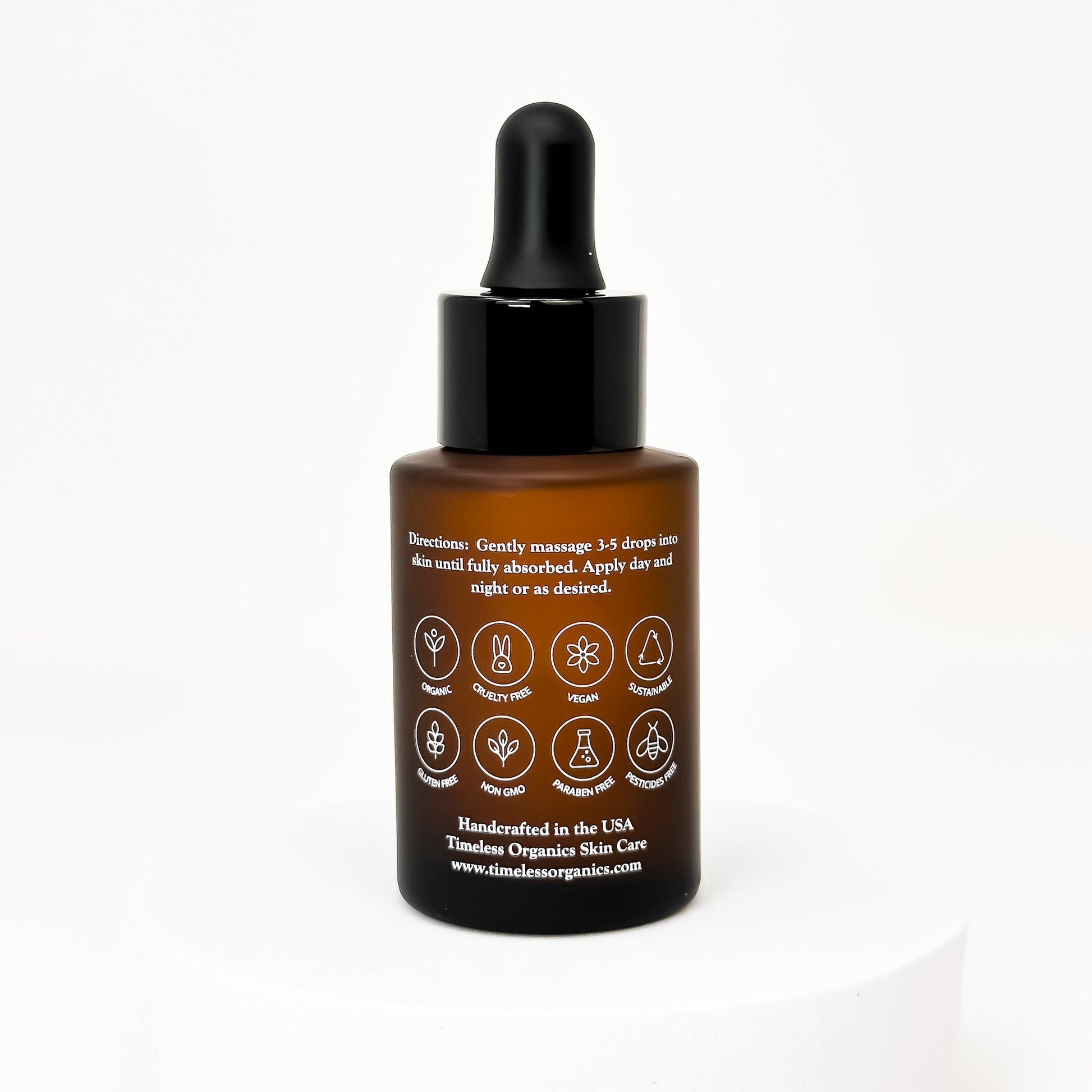 Face oil bottle with black dropper, back label side shown on amber glass