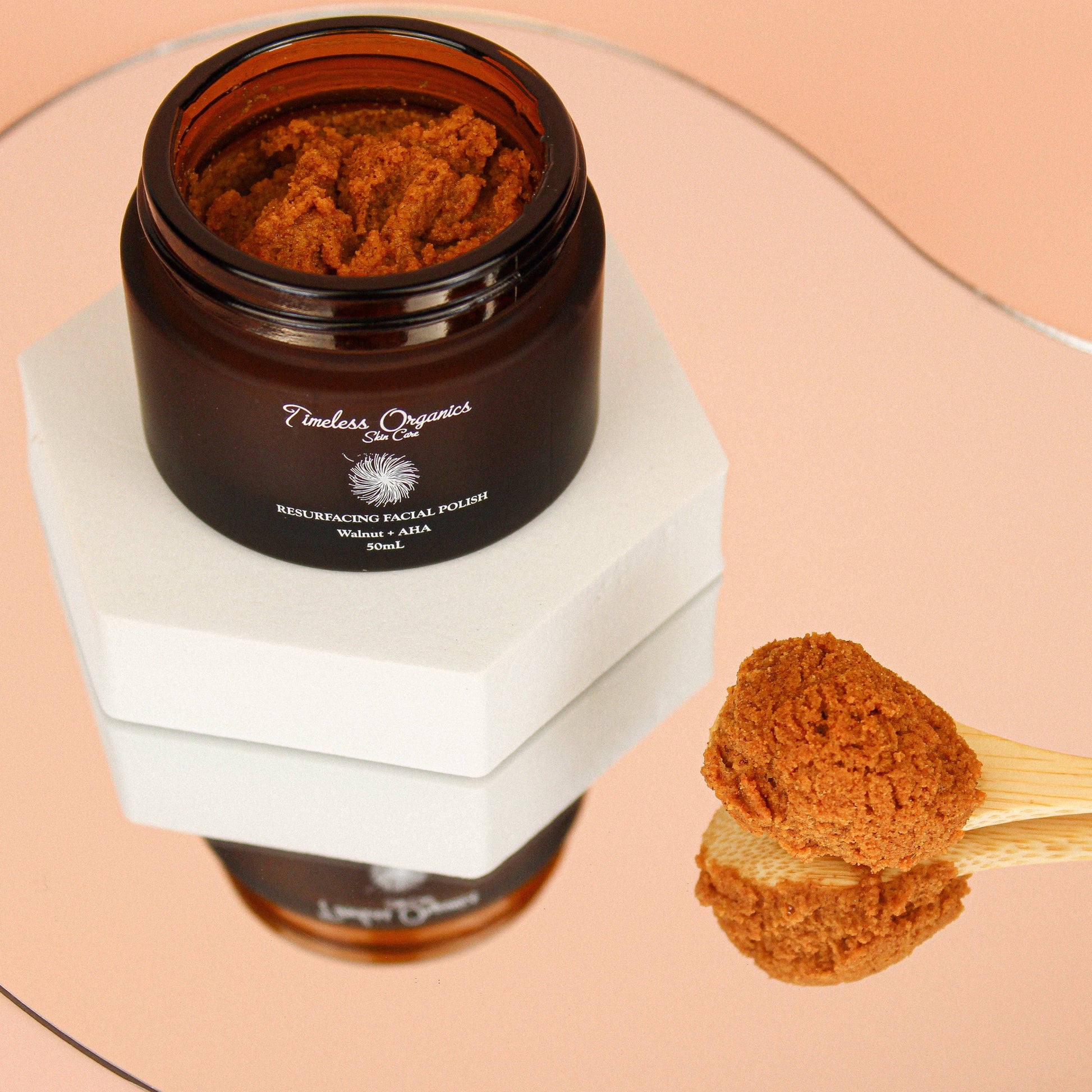 Walnut + AHA resurfacing facial polish jar with orange exfoliating granules