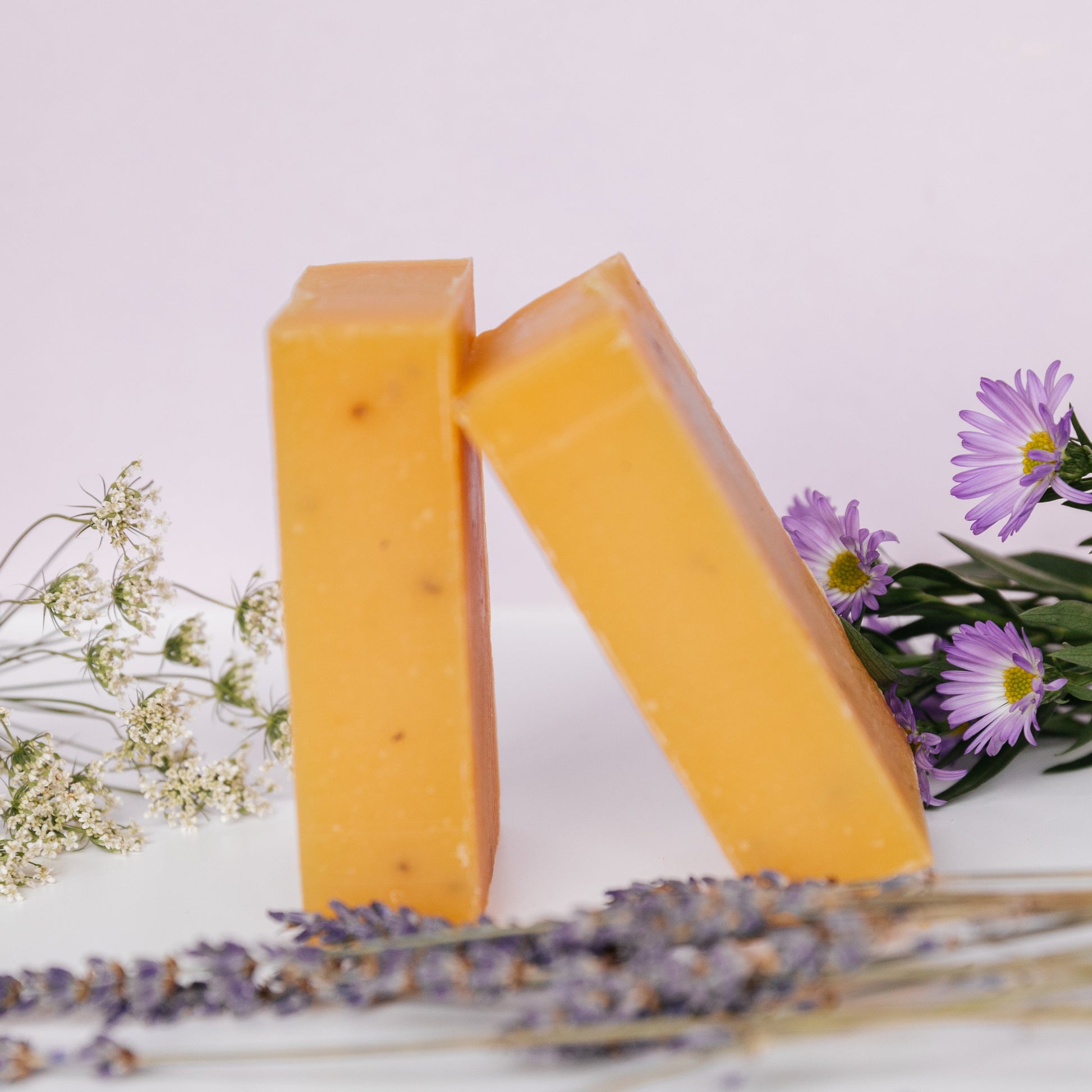 Exfoliating bar soap, orange-yellow with specks; two rectangular soap bars