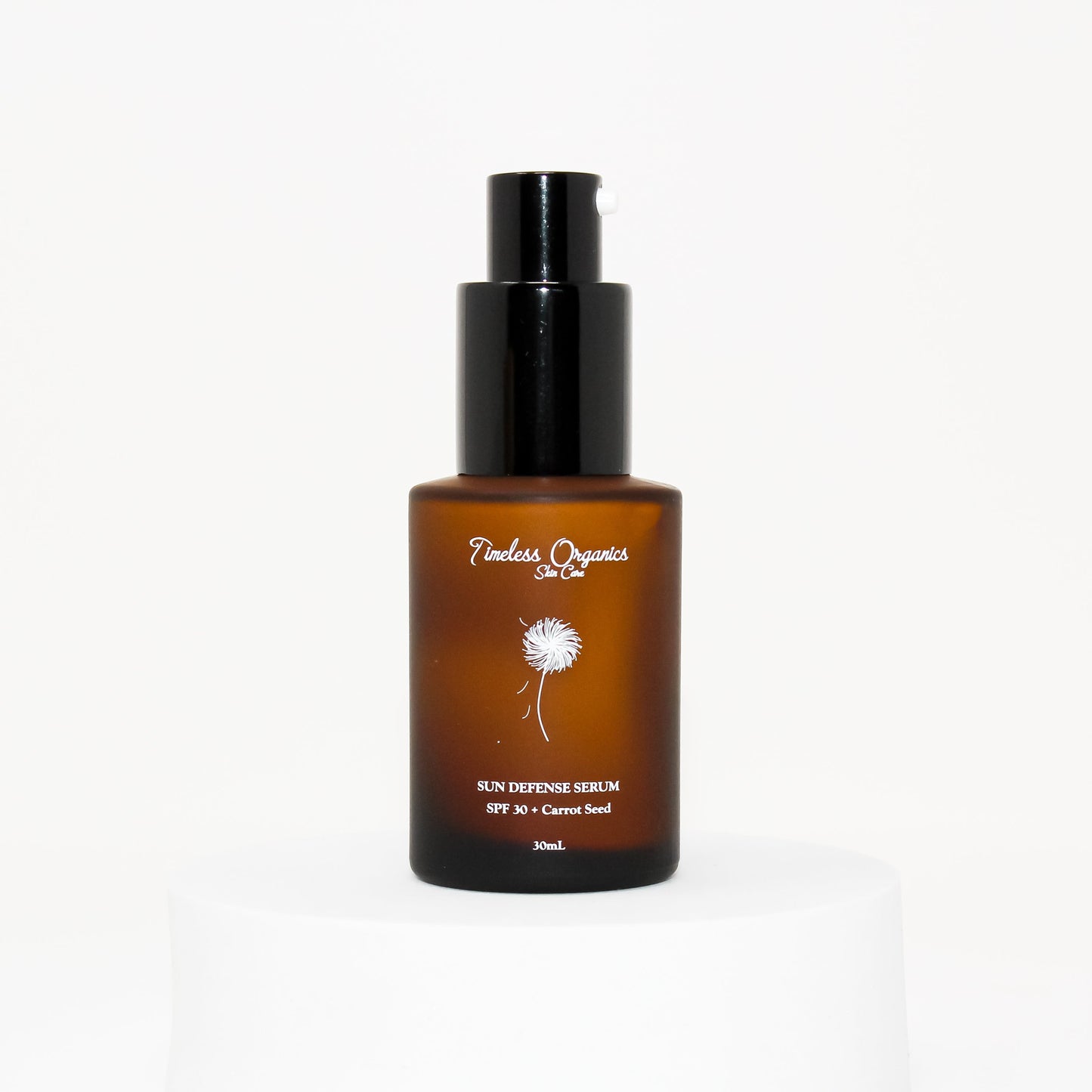 Sun defense serum SPF 30 bottle with black pump, amber with carrot seed label.