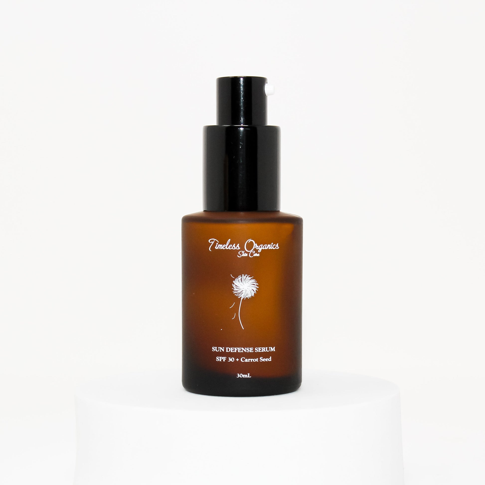 Sun defense serum SPF 30 bottle with black pump, amber with carrot seed label.