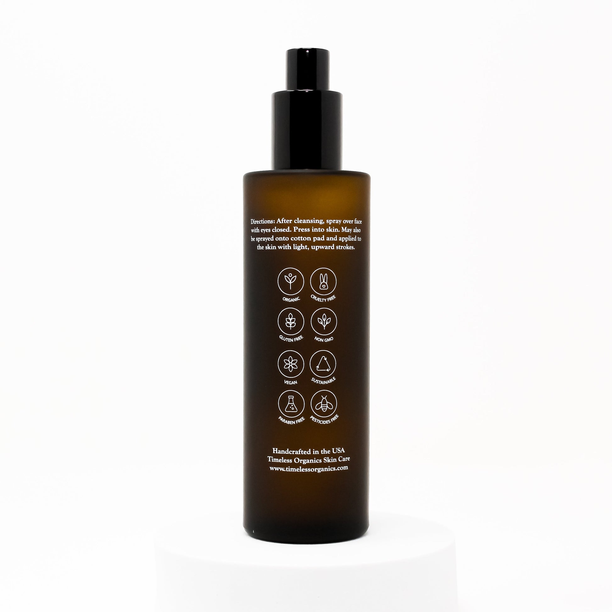 Hydrating face & body mist bottle with black pump, amber bottle, back label icons